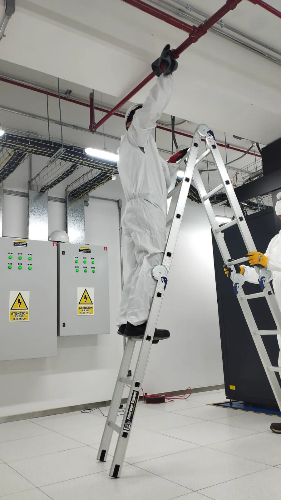 Técnico limpiando instalaciones superiores en un centro de datos